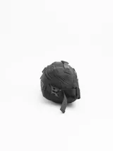 Riñonera negra de diseño funcional con múltiples compartimentos. Cuenta con dos bolsillos frontales con cierre, un bolsillo trasero oculto de seguridad y una manija superior. Incluye correa ajustable con cierre de broche y parche con logo de la marca en el frente.