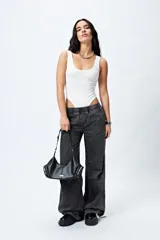 Pantalón jean ancho color gris oscuro, con elástico en la cintura, cordones ajustables en los bajos y grandes bolsillos laterales y traseros.