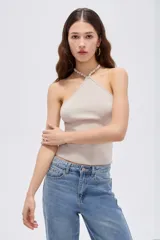 Top de viscosa color marrón, con diseño al cuerpo, escote halter y detalle de cuentas en el cuello.