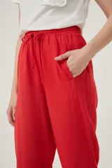 Pantalón babucha rojo de tela rústica con cintura elastizada y cordón ajustable.