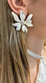 Caravana de diseño floral en color blanco con bordes plateados y centro con incrustaciones de cristales brillantes.