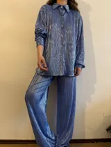 Camisa plisada color celeste con brillo, de corte holgado y manga larga con puños elásticos.