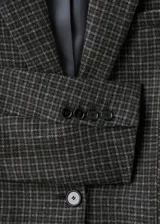 Blazer de corte recto confeccionado en tejido mezcla de lana con diseño de cuadros. Presenta cuello con solapas de muesca, cierre frontal de un botón, mangas largas con puños abotonados, bolsillo de ribete en el pecho y dos bolsillos con solapa en la parte frontal. Incluye forro interior.