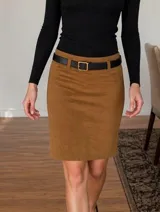 Falda midi de corte recto en color tostado, confeccionada en tejido tipo velvet con textura suave. Presenta un diseño de silueta limpia con tajos laterales y viene acompañada de un cinturón negro con hebilla metálica.