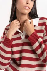 Buzo de lana con diseño de rayas horizontales en color bordó y beige. Presenta cuello tipo polo con cierre frontal de un botón y puños acanalados.