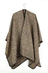 Poncho tipo ruana con estampado animal print en tonos beige y negro, con terminaciones en crochet negro.