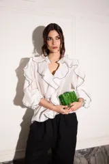 Camisa blanca con volados con terminación de hilo negro en cuello, mangas y frente.