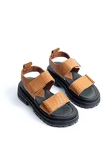 Sandalias negras con diseño de plataforma dentada y tiras ajustables con cierre de velcro. Presentan un acabado texturizado tipo croco.