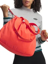 Cartera tipo tote Under Armour modelo Studio Cinch Tote, color naranja, con tecnología UA Storm resistente al agua, compartimento principal con cierre ajustable mediante cordón y correas de hombro de cincha.