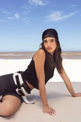 Cinto faja de cuero con estampado de vaca en blanco y negro, con hebilla metálica rectangular.