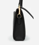 Cartera bandolera pequeña de poliuretano negro, con correa larga y cierre de cremallera.