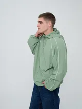 Campera rompevientos Umbro modelo Venti, de color negro con líneas blancas en las mangas y hombros, capucha con cordón de ajuste y cierre frontal completo. Cuenta con el logo de la marca bordado en el pecho.