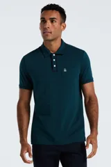 Chomba de piqué color verde petróleo, con cuello clásico, cierre frontal de tres botones y bolsillo frontal con logo bordado de la marca Original Penguin.