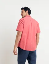 Camisa sport de manga corta, confeccionada en una mezcla de lino y algodón. Presenta cuello clásico, cierre frontal con botones de coco y un bolsillo aplicado en el pecho.