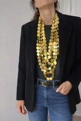 Collar largo de múltiples capas compuesto por discos circulares de madera en color negro, con diseño orgánico y liviano.