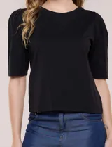 Remera de algodón negro, de silueta semi entallada, con escote redondo y mangas cortas abullonadas al codo con frunces en los hombros.