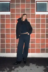 Anorak de corte corto y diseño minimalista, color negro. Cuenta con capucha integrada, cierre frontal con cremallera termosellada, bolsillos laterales con cierre y puños interiores elásticos. Posee acolchado interior y propiedades resistentes al agua y al viento.