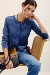 Cardigan de punto con efecto denim, cuello redondo, cierre frontal con botones y mangas largas con puños acanalados.