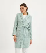 Bata corta en color verde agua, confeccionada en fleece con textura en relieve. Tiene mangas largas, cuello tipo chal y lazo para ajustar en la cintura.