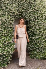 Conjunto color crudo compuesto por un top calado y bordado, y un pantalón de pierna ancha pinzado con bolsillos.