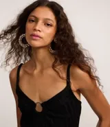 Vestido midi negro de microfibra con efecto punto, escote en V con adorno metálico redondo y breteles finos.