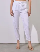 Pantalón jogger blanco de tencel con pretina ancha elastizada, lazo de ajuste, bolsillos delanteros y laterales, y puño elastizado en el ruedo.