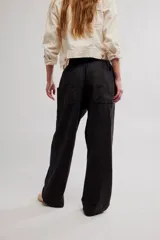 Pantalon de lino y algodon color beige, de tiro bajo, estilo relajado con cintura elastizada ajustable mediante cordón y bolsillos laterales.