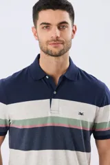 Remera polo de manga corta con diseño de franjas horizontales en tonos azul, beige, verde y terracota. Presenta cuello camisero con cierre frontal de dos botones y un pequeño bordado en el pecho.