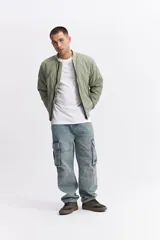 Campera tipo bomber de nylon color verde oliva, con cierre frontal, cuello, puños y cintura elastizados.