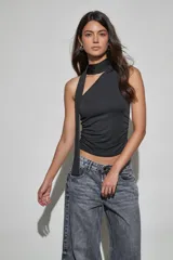 Top negro sin mangas con diseño de cuello halter y detalle de tira larga lateral. Presenta un ajuste entallado con frunces en los laterales.