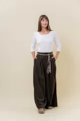 Pantalón wide leg de tiro alto en color negro, con diseño de pinzas delanteras que aportan volumen y caída fluida. Incluye bolsillos laterales y un lazo desmontable en la cintura que combina cordón con cinta de estampado animal print.