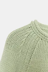 Jersey de punto grueso con cuello redondo, manga larga y diseño de bajo asimétrico.