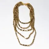 Collar dorado de múltiples hilos con cuentas redondas.