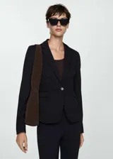 Blazer negro de corte recto y diseño clásico, con cuello de solapa con muesca, cierre frontal de un botón y dos bolsillos laterales con solapa.