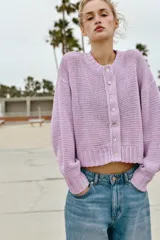 Chaqueta de punto grueso color lila con cuello redondo, manga larga, acabados en rib y cierre frontal con botones nacarados.