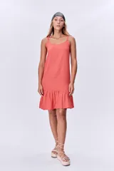 Vestido corto color salmón, de breteles finos y corte recto con volado en el ruedo.