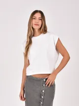 Remera blanca de manga corta y cuello redondo, con diseño holgado y hombros ligeramente caídos.