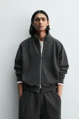 Sudadera de algodón con interior en rizo afelpado, cuello subido, manga larga y cierre frontal de cremallera. Presenta un efecto lavado que le da una apariencia única y bolsillos frontales ocultos en las costuras.