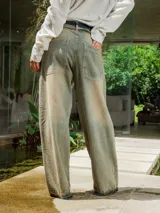 Pantalón de jean de lavado claro (oxido), corte ancho y tiro bajo, con cordones ajustables a la vista en la cintura y bordado en el frente.