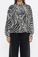 Camisa corta de pana con estampado de cebra y leopardo. Modelo de corte boxy, cuello con tira, manga larga con puño y botones de presión, cierre frontal con botonadura de presión y bolsillo de plastrón en el pecho.