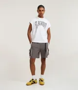 Bermuda de poliéster color gris oscuro, estilo baggy, con cintura elástica y cinturón ajustable negro. Presenta bolsillos cargo laterales con recortes en color claro y detalles de tiras negras.