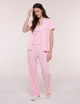 Set de pijama de tres piezas color rosado con estampado geométrico sutil. Incluye una camisa de manga corta con solapa y botones, una musculosa básica con escote en V y un pantalón largo de corte recto con cintura elastizada y cordón ajustable.