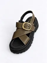 Sandalias de plataforma con suela track marrón, tiras cruzadas en el empeine de color marfil y marrón, y tira ajustable al talón con hebilla metálica dorada.