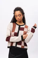 Saco tipo cardigan de punto con diseño geométrico de bloques en tonos beige, marrón y bordó. Presenta cuello redondo, cierre frontal con botones negros y mangas largas con puños en contraste.