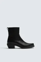Bota estilo cowboy de caña media, color negro, con punta cuadrada, tacón bajo y cierre lateral.
