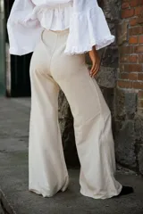 Pantalón de corte amplio y relajado, confeccionado en una mezcla de lino y algodón. Presenta una caída fluida, cintura alta y bolsillos laterales.