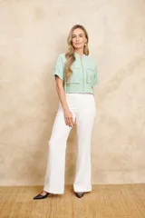 Chaqueta bomber corta color verde agua, con cierre frontal dorado, bolsillos grandes con cierre y mangas cortas ajustables con lazos.