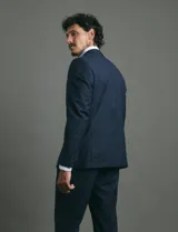 Traje de corte slim fit compuesto por saco de dos botones y pantalón de vestir a juego. Presenta una silueta entallada y moderna.