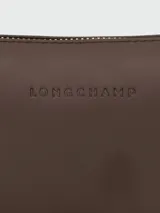 Cartera de hombro Longchamp modelo Looong en tamaño pequeño, confeccionada en cuero de color marrón oscuro. Presenta una silueta estructurada y minimalista con correa de hombro fija.