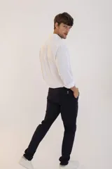 Pantalon de corte recto y ajuste slim, color azul marino, con cierre de botón y cremallera, bolsillos laterales y traseros.